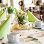 Bild des, mit grünen Farbakzenten, schön dekorierten, Frühstücksraumes